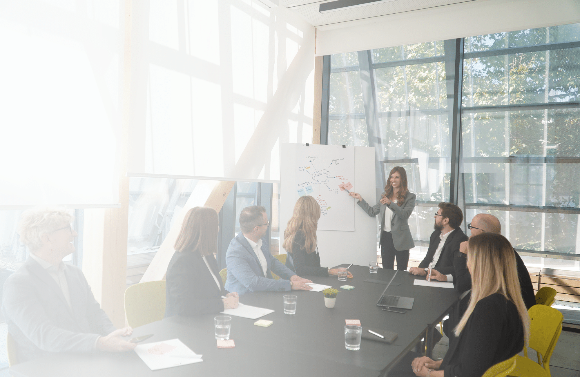 Frau erklärt am Flipchart etwas fürs Team