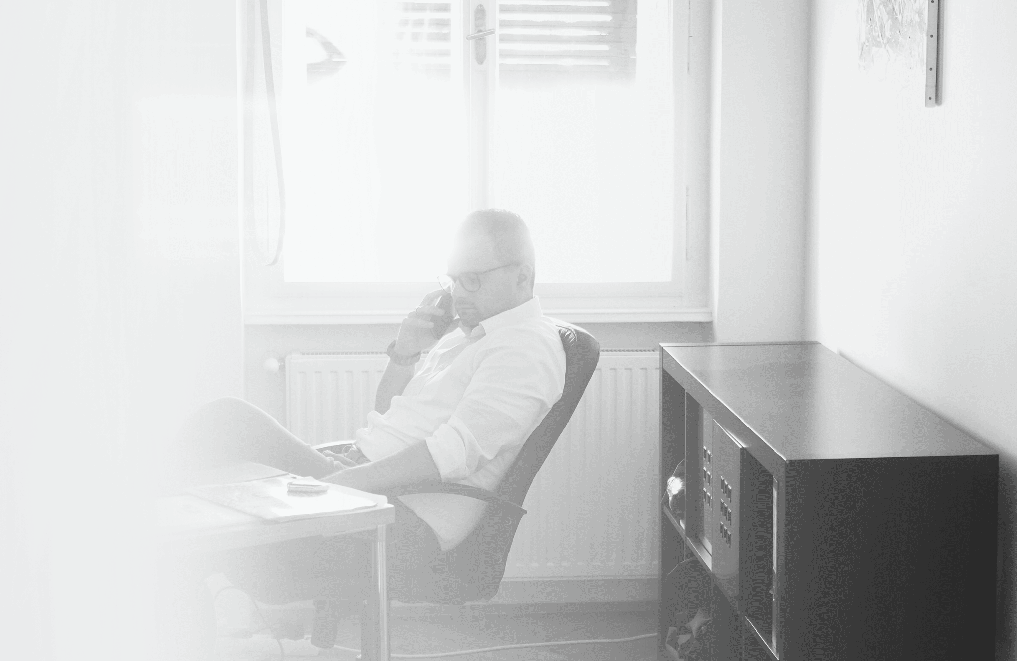 Mann sitzt am Schreibtisch und telefoniert
