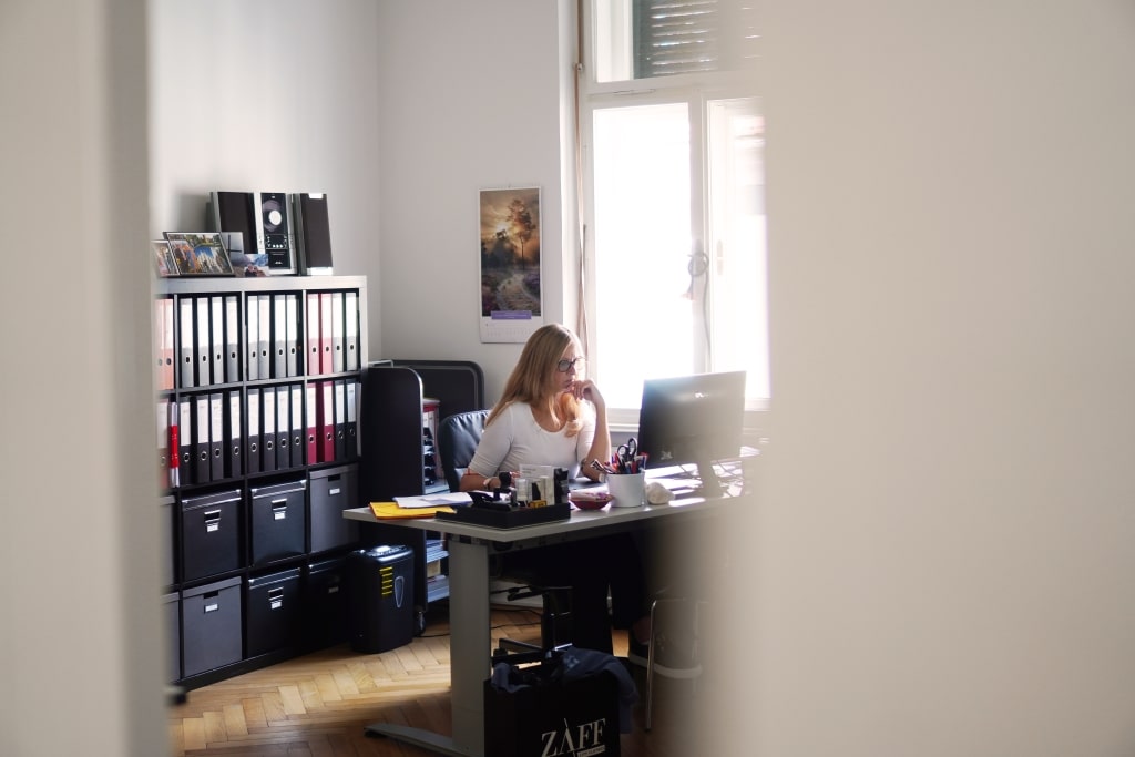 Frau sitzt konzentriert am Schreibtisch