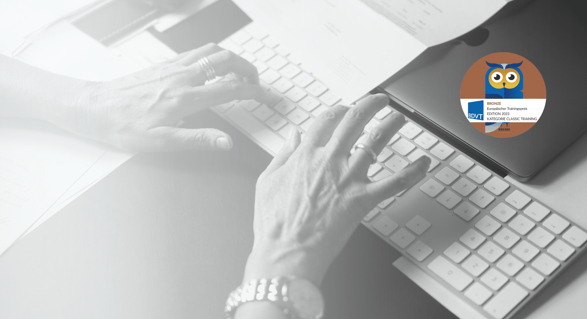 schwarz-weiß Bild wo Frauenhände auf einer Tastatur tippen